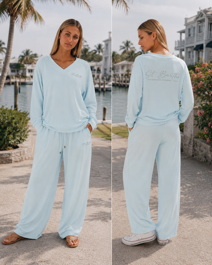 model wearing matching set in sheer blue with st. Barths screen print design pocket and back print. In coastal US town by marina.